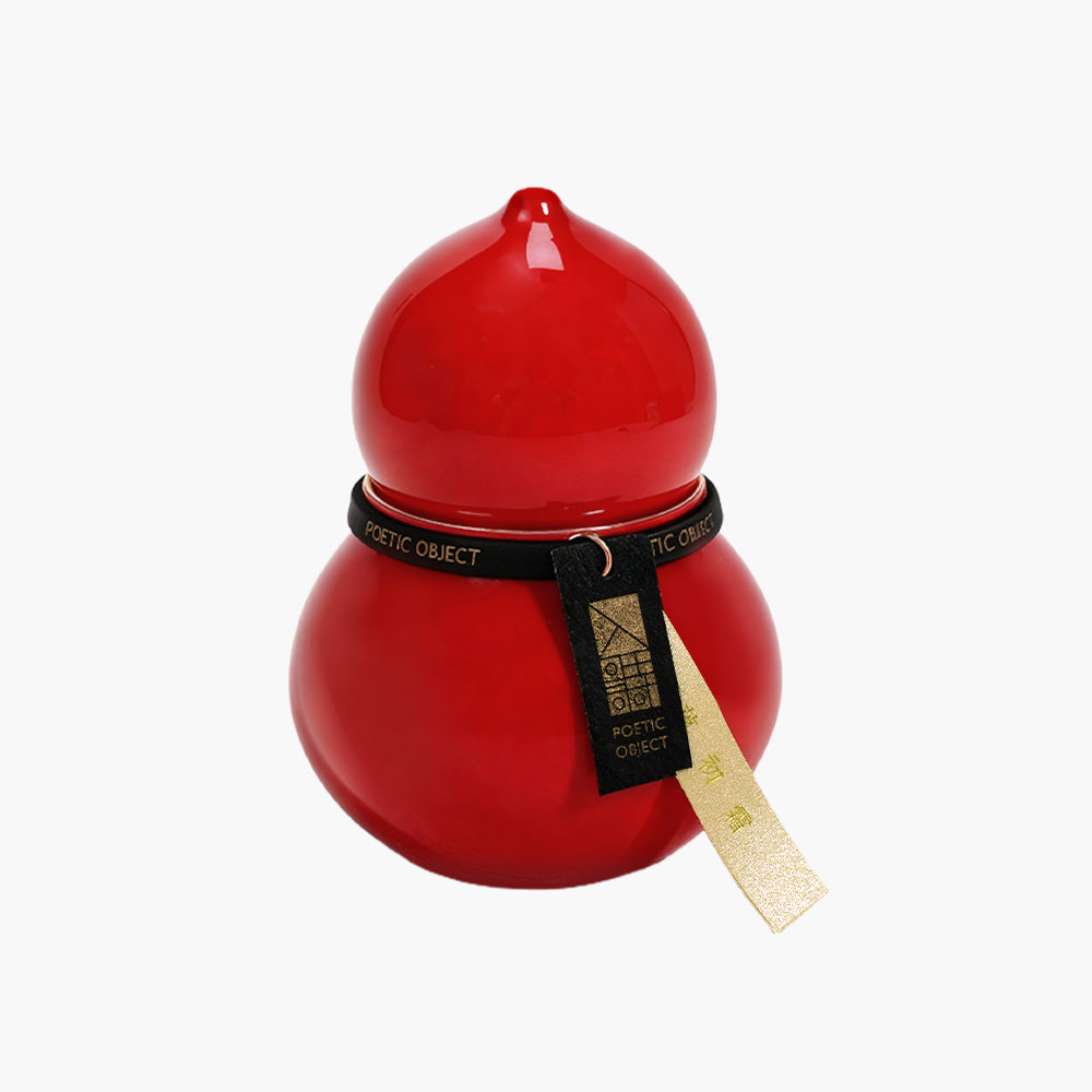 Front view of a high-fired red porcelain candle vessel with a hand-gilded gold rim, an artisanal home accent for a sophisticated interior.