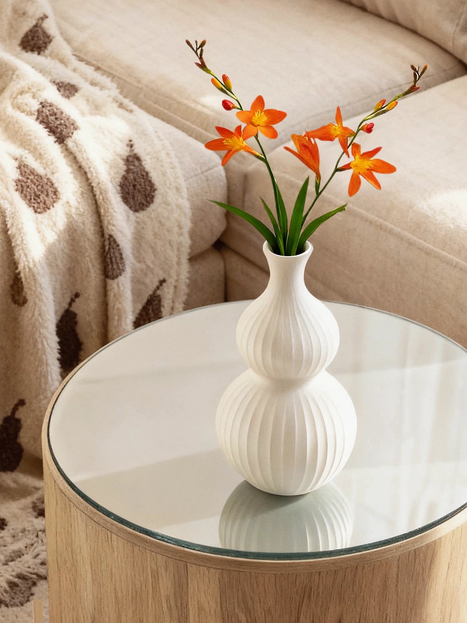 Modern white ribbed ceramic vase with vibrant orange flowers on a side table, HOOHLU designer decor for a cozy home.